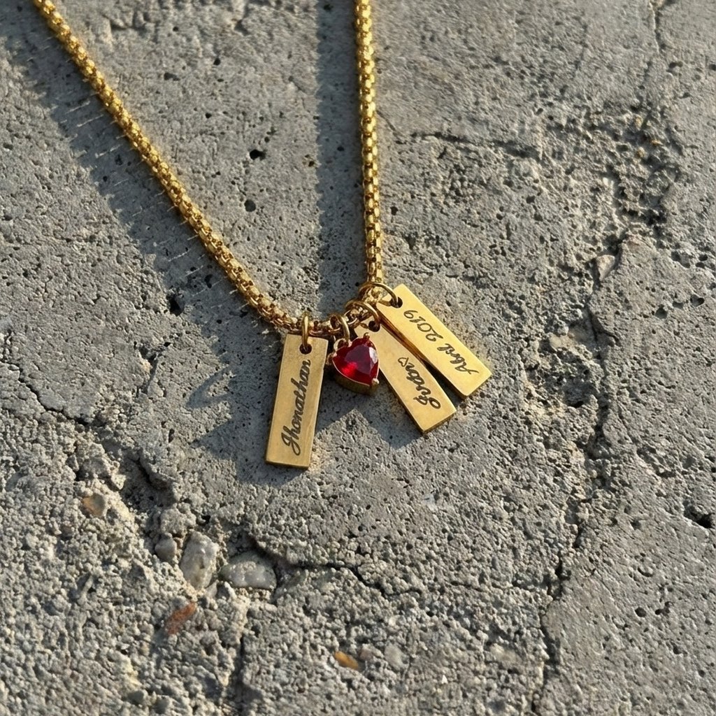 Collar con tres Mini Tag 18 dorados grabados con nombres y una fecha, con un corazón rojo